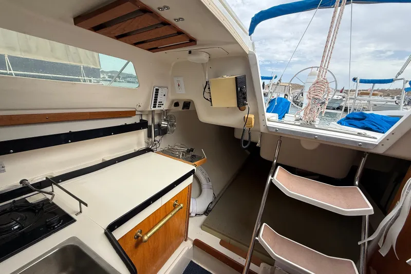 Slide: The Image of Interior of a 1998 Catalina 250 sailboat with compact kitchen and cockpit view. - 21
