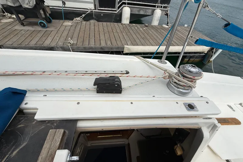 Slide: The Image of Deck of a 1998 Catalina 250 sailboat with winch and ropes near a dock. - 36