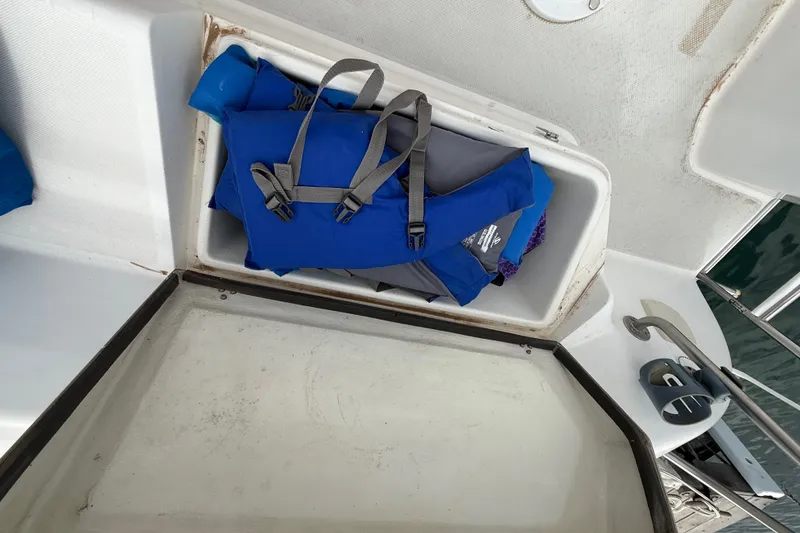 Slide: The Image of Storage compartment on a 1998 Catalina 250 sailboat with blue life jackets. - 40