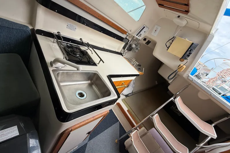 Slide: The Image of Interior of a 1998 Catalina 250 sailboat featuring a compact kitchen area. - 15