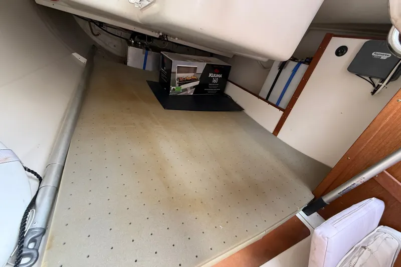 Slide: The Image of Interior of a 1998 Catalina 250 sailboat, featuring storage space and equipment. - 14