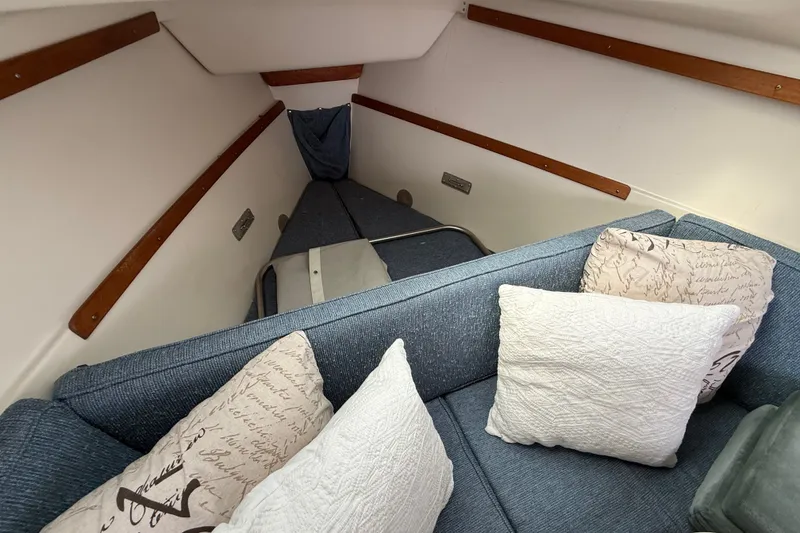 Slide: The Image of Interior of a 1998 Catalina 250 sailboat with cozy seating and decorative pillows. - 17