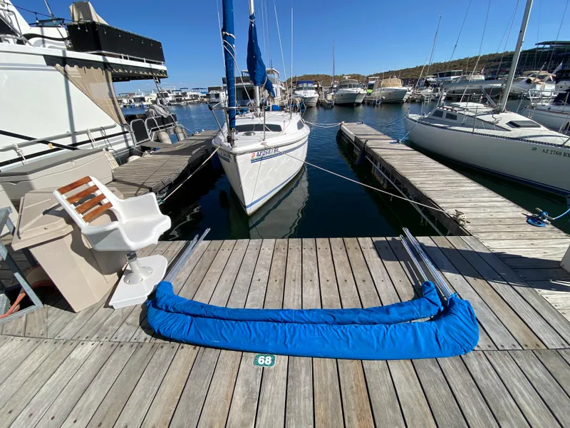Slide: The Image of A white sailboat docked at a wooden pier in a busy marina. - 5