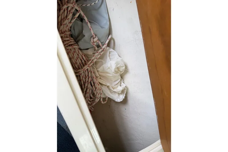 Slide: The Image of Coiled rope and fabric inside a 1998 Catalina 250 sailboat compartment. - 45