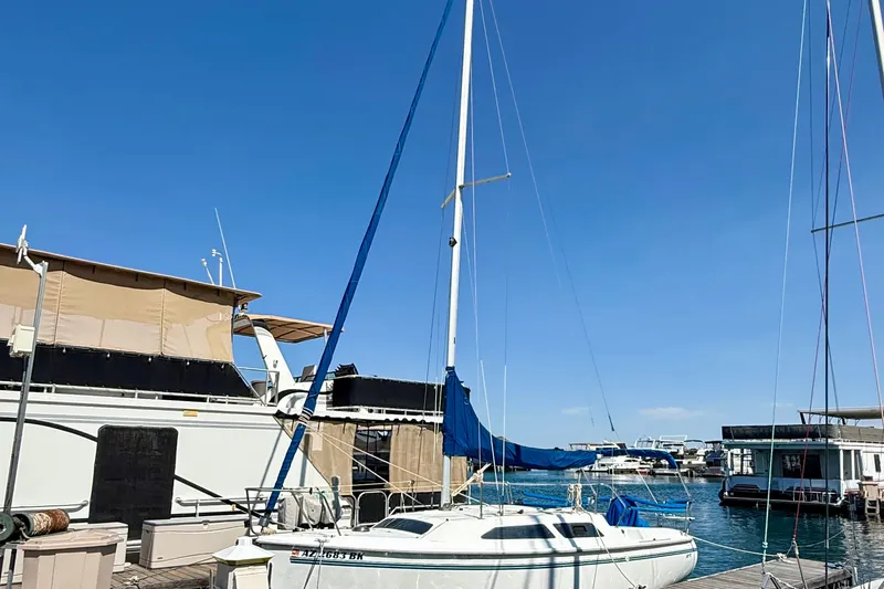Slide: The Image of 1998 Catalina 250 sailboat docked at a marina under a clear blue sky. - 10