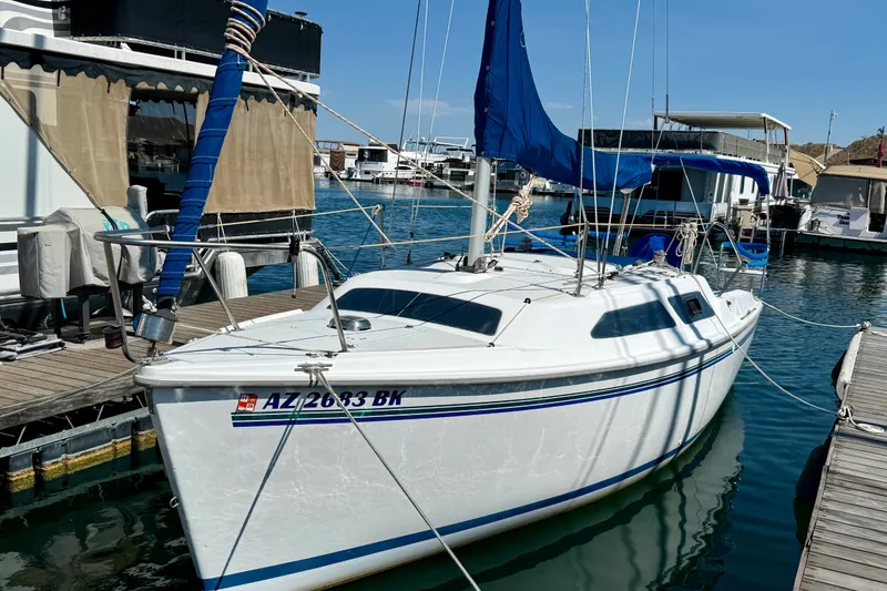 Slide: The Image of 1998 Catalina 250 sailboat docked at marina, featuring blue sail cover and sleek white hull. - 9