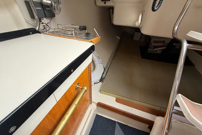 Slide: The Image of Interior of a 1998 Catalina 250 sailboat featuring a compact kitchen area. - 13