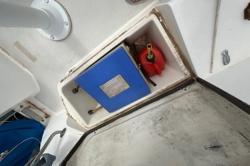 Slide: The Image of Storage compartment on a 1998 Catalina 250 sailboat with blue box and red fuel container. - 41
