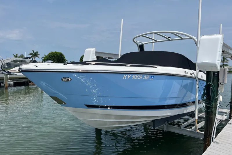 Slide: The Image of 2024 Monterey 275SS Super Sport boat docked on a lift in a marina. - 1