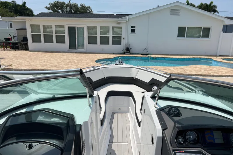 Slide: The Image of 2024 Monterey 275SS Super Sport boat docked by a poolside patio. - 10