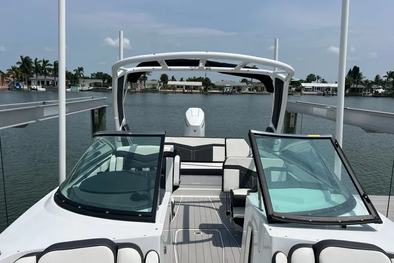 Slide: The Image of 2024 Monterey 275SS Super Sport boat docked on a serene waterfront. - 18