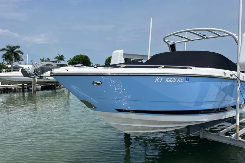 Slide: The Image of 2024 Monterey 275SS Super Sport boat docked in a marina, blue hull, sunny day. - 2