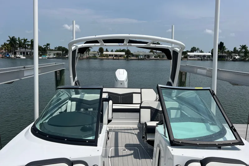 Slide: The Image of 2024 Monterey 275SS Super Sport boat docked on a serene waterfront. - 19