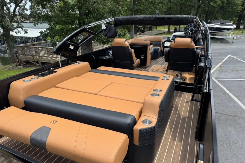 Slide: The Image of Luxurious 2027 Premier 230 Intrigue RLO - DL boat with tan and black seating, docked near trees. - 9