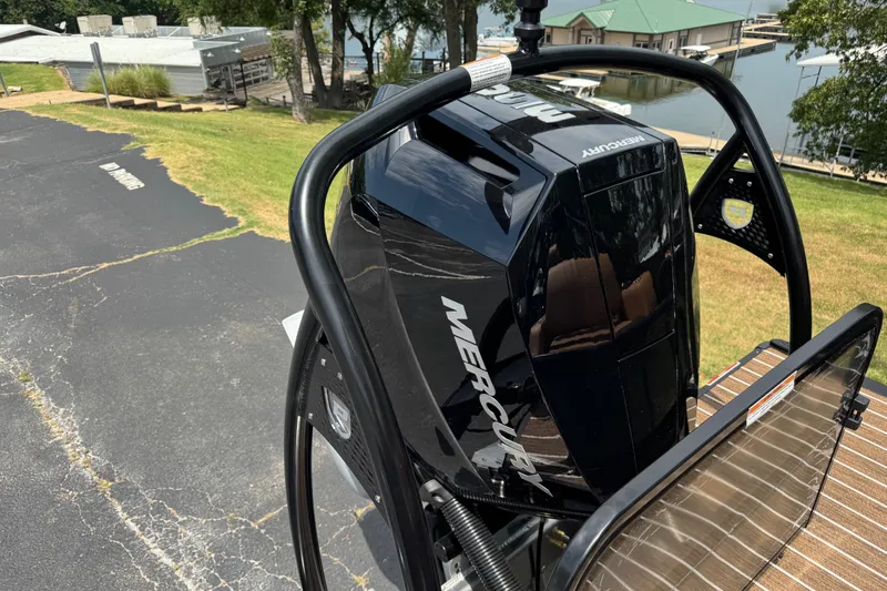 Slide: The Image of 2027 Premier 230 Intrigue RLO - DL with Mercury outboard engine near a lakeside dock. - 13