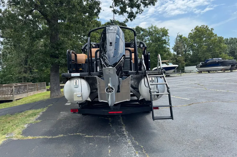 Slide: The Image of 2027 Premier 230 Intrigue RLO - DL pontoon boat parked, rear view with motor and ladder. - 16