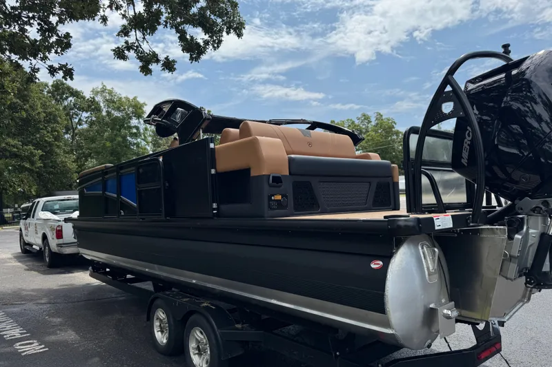 Slide: The Image of 2027 Premier 230 Intrigue RLO - DL pontoon boat on trailer, parked outdoors. - 3