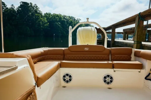 Slide: The Image of 2027 Key West 239 DFS boat interior with brown seating, docked by a serene lake. - 18