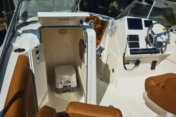 Slide: The Image of 2027 Key West 239 DFS boat interior with helm and compact toilet area. - 13
