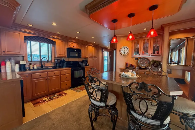 Slide: The Image of Luxurious kitchen interior in 2008 Funtime 16x70 houseboat with elegant lighting and wooden cabinetry. - 23