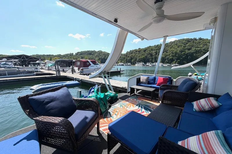 Slide: The Image of Cozy outdoor seating on 2008 Funtime 16x70 houseboat docked by scenic lake. - 47
