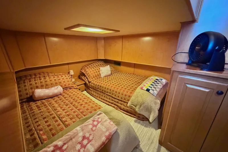 Slide: The Image of Cozy twin bedroom in 2008 Funtime 16x70 houseboat with warm lighting and patterned bedding. - 39