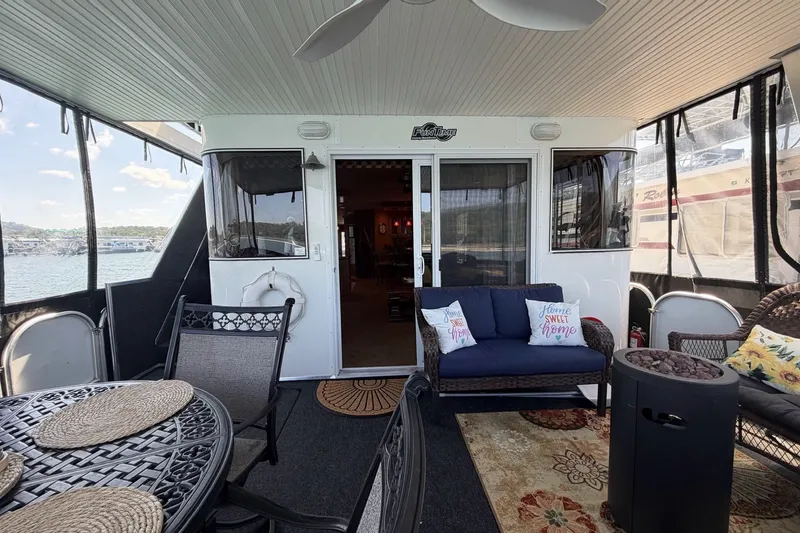 Slide: The Image of Cozy 2008 Funtime 16x70 houseboat deck with seating, table, and lake view. - 14