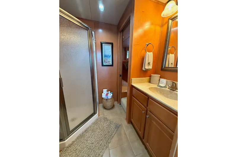 Slide: The Image of Bathroom interior of 2008 Funtime 16x70 with shower, vanity, and wooden cabinetry. - 36