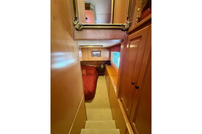 Slide: The Image of Cozy bedroom in 2008 Funtime 16x70 houseboat with wooden interior and red bedding. - 26