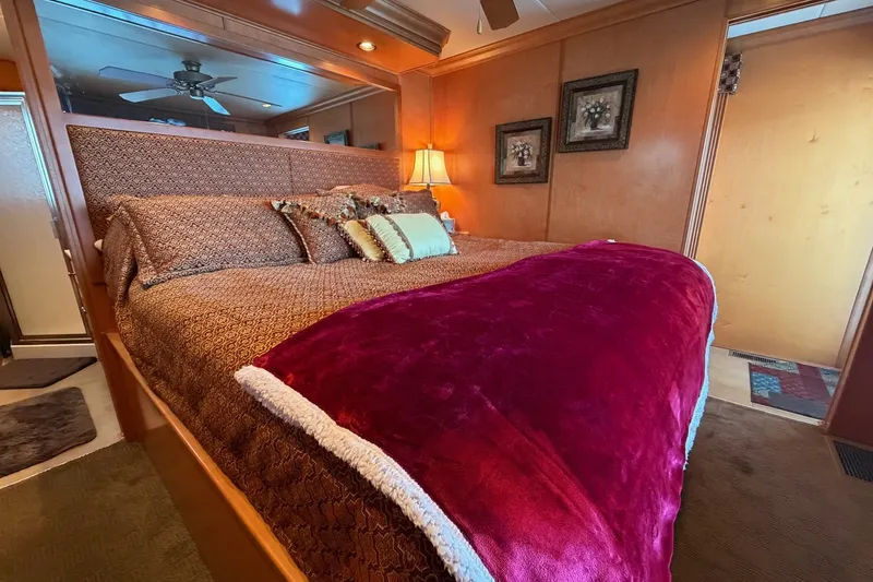 Slide: The Image of Luxurious bedroom in 2008 Funtime 16x70 houseboat with plush bedding and warm lighting. - 43