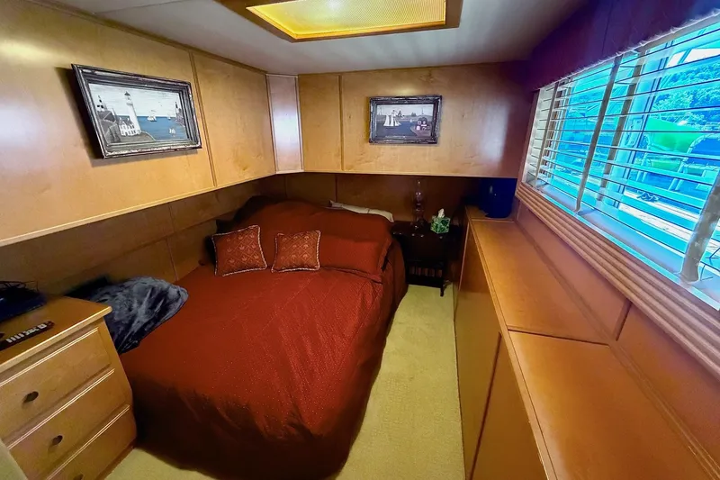 Slide: The Image of Cozy bedroom in 2008 Funtime 16x70 houseboat with wood paneling and nautical decor. - 27