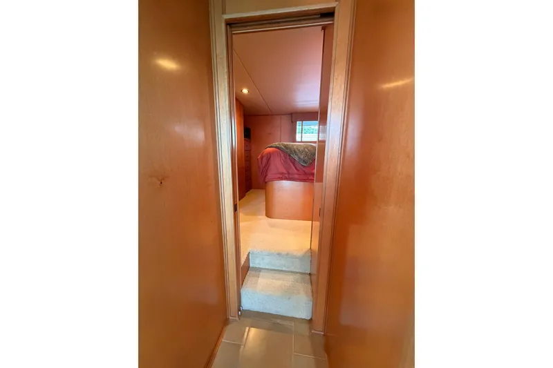 Slide: The Image of Interior view of 2008 Funtime 16x70 boat bedroom with wooden walls and carpeted steps. - 32