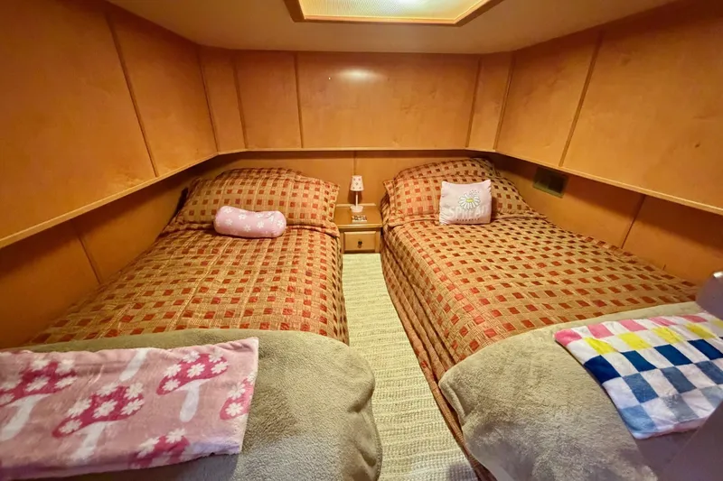 Slide: The Image of Cozy twin bedroom in 2008 Funtime 16x70 boat with patterned bedding and wooden paneling. - 40