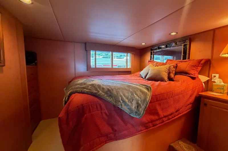 Slide: The Image of Cozy bedroom in 2008 Funtime 16x70 houseboat with red bedding and decorative pillows. - 33