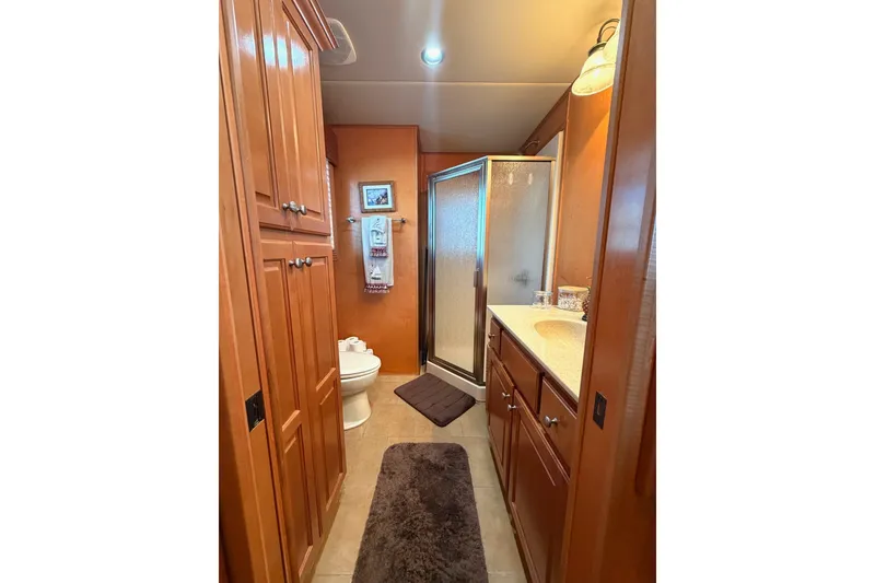 Slide: The Image of Compact bathroom in 2008 Funtime 16x70 with wooden cabinets and shower. - 44