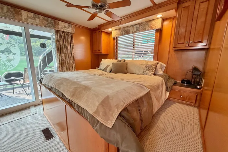 Slide: The Image of Cozy bedroom with wooden cabinetry, large bed, ceiling fan, and sliding glass door to patio. - 31