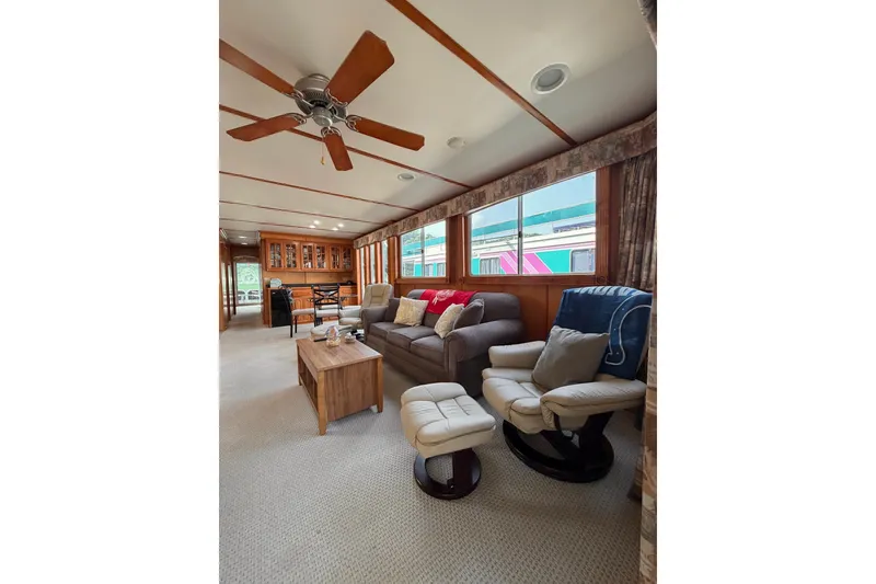 Slide: The Image of Cozy Lakeview houseboat interior with comfortable seating, ceiling fan, and large windows. - 10