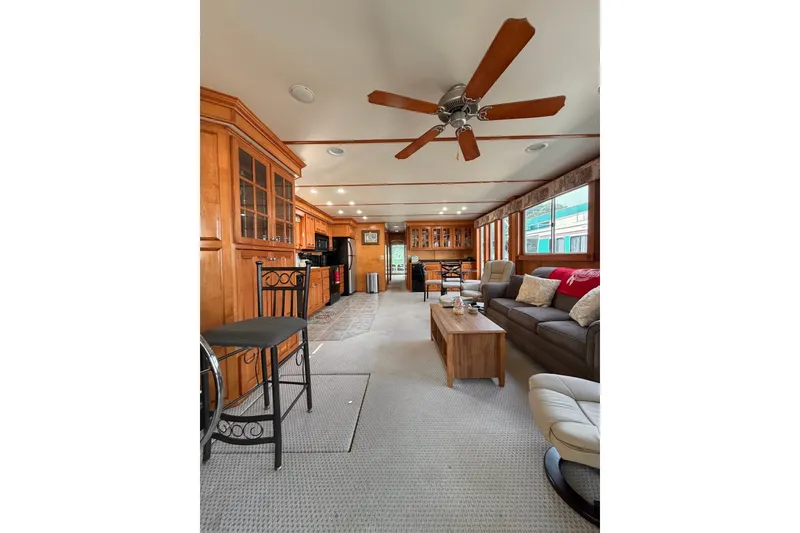 Slide: The Image of Spacious Lakeview houseboat interior with wooden cabinetry, ceiling fan, and cozy seating area. - 9