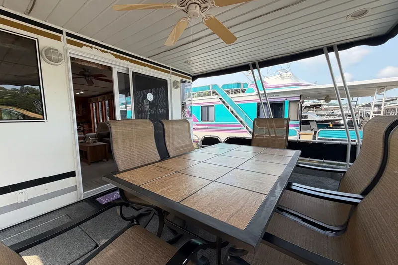 Slide: The Image of Outdoor dining area on a Lakeview houseboat with table, chairs, and ceiling fan. - 3