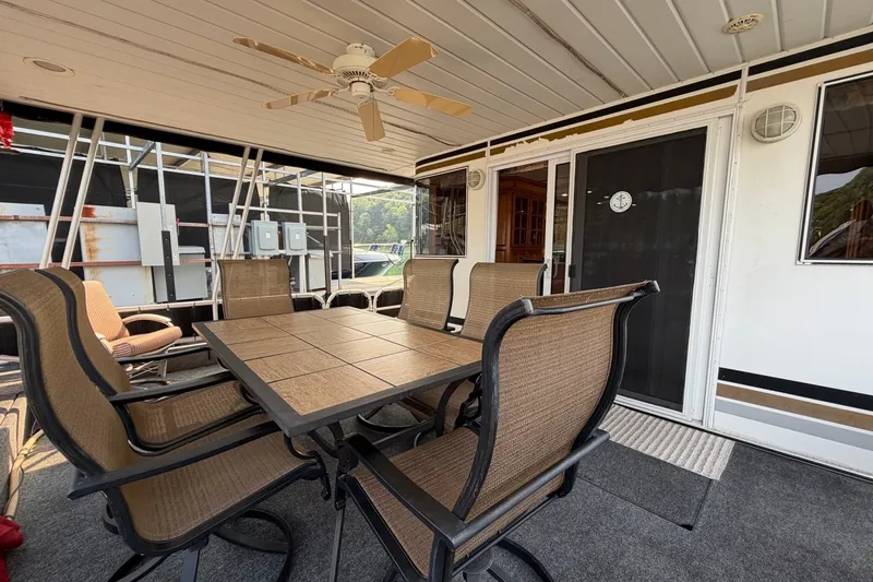 Slide: The Image of Outdoor seating area on a Lakeview houseboat with table, chairs, and ceiling fan. - 1