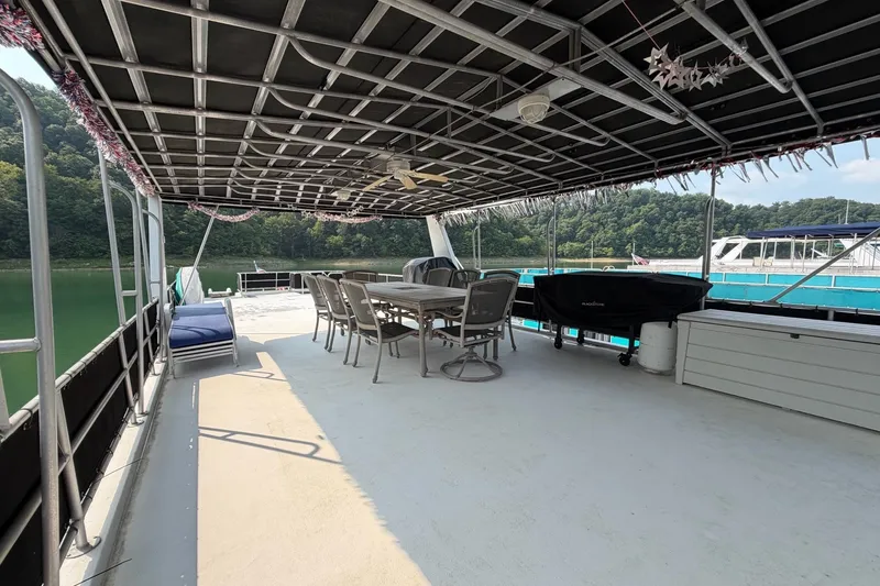 Slide: The Image of Spacious Lakeview boat deck with seating, dining table, and scenic water view. - 39