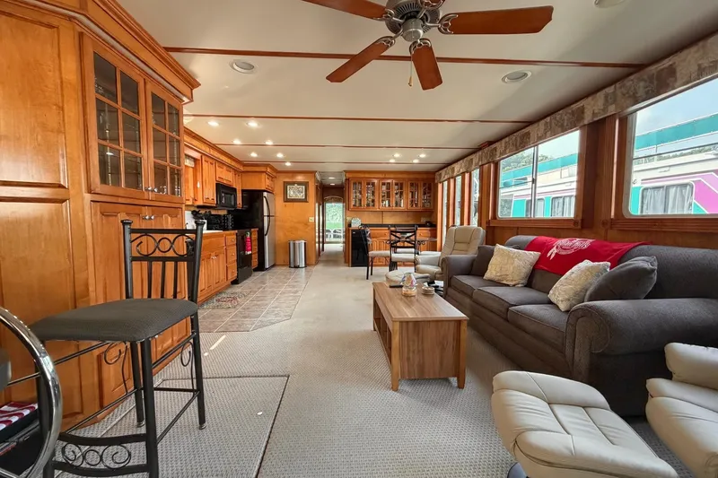 Slide: The Image of Luxurious Lakeview houseboat interior with wooden cabinetry, cozy seating, and large windows. - 5
