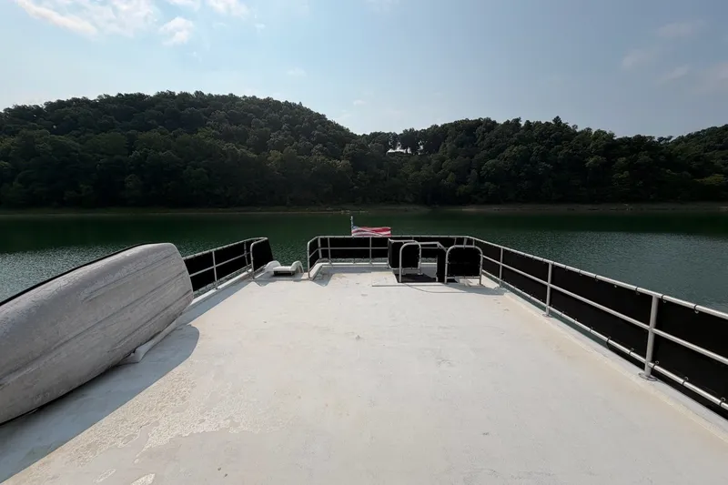 Slide: The Image of Boat deck overlooking a serene lake with lush green hills in the background. - 47