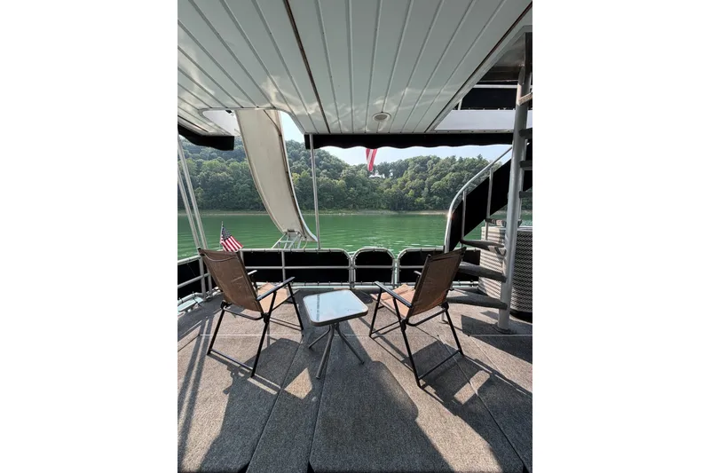 Slide: The Image of Deck view from Lakeview boat with chairs, table, and scenic lake backdrop. - 36