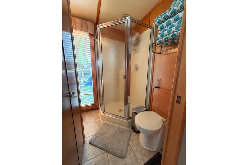Slide: The Image of Compact bathroom with glass shower, toilet, and teal towels on a rack. - 19