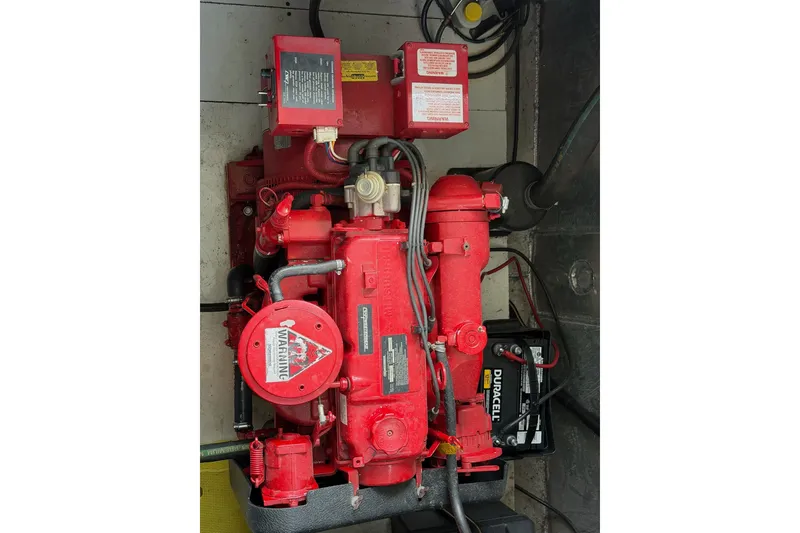 Slide: The Image of Red Lakeview engine with warning label and Duracell battery in a mechanical setup. - 53