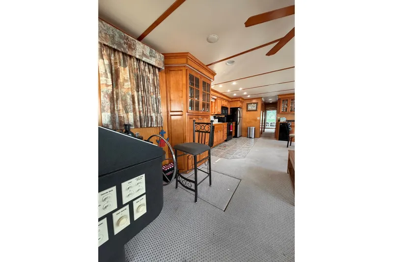 Slide: The Image of Interior of a Lakeview houseboat featuring a cozy kitchen and dining area with wooden cabinetry. - 8
