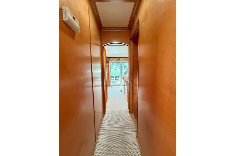 Slide: The Image of Narrow wooden hallway with carpet, leading to a bright room with glass doors. - 22