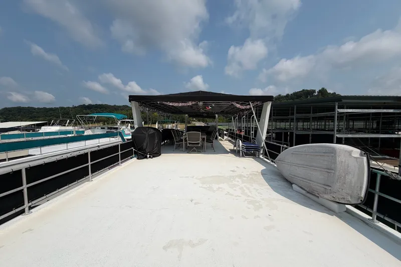 Slide: The Image of Rooftop deck of a Lakeview houseboat with chairs and canopy under a blue sky. - 48
