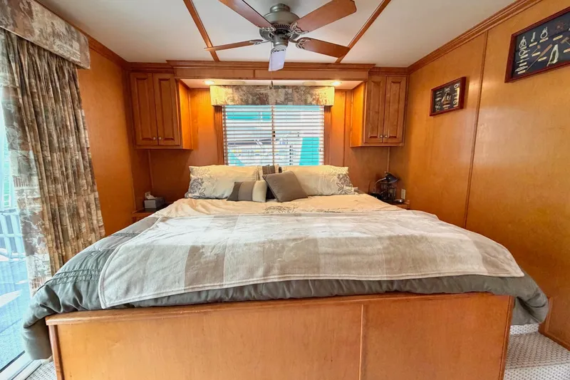 Slide: The Image of Cozy bedroom with wooden decor, ceiling fan, and large bed in a Lakeview model. - 35